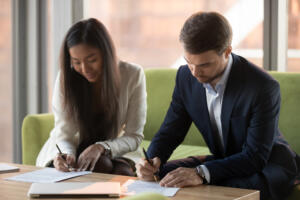 Young couple in an office signing prenuptial agreements