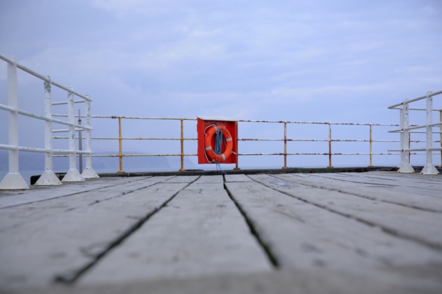 photo of a lifebuoy on a pier overlooking the water