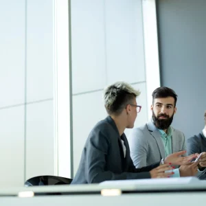 Meeting taking place in a modern office between one woman and two men