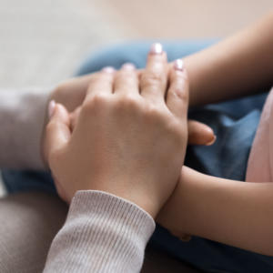 Mom giving support to little daughter by holding hands