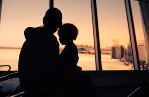 Mother and her little son in silhouette waiting for boarding in the airport.