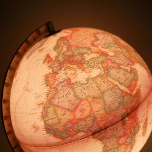 World globe ornament showing numerous countries and bathed in a warm light