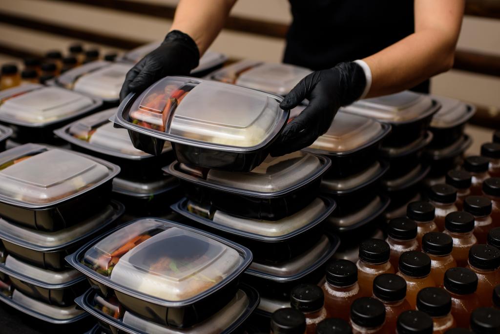 Food preparer packaging up takeaway food for delivery.