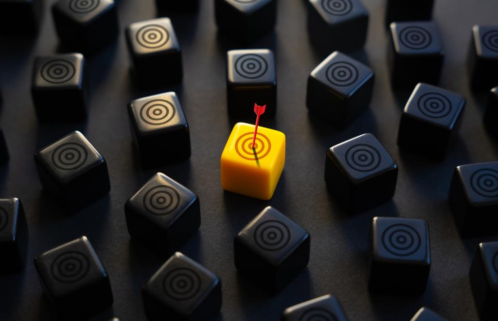 An arrow landing on a yellow target surrounded by black targets