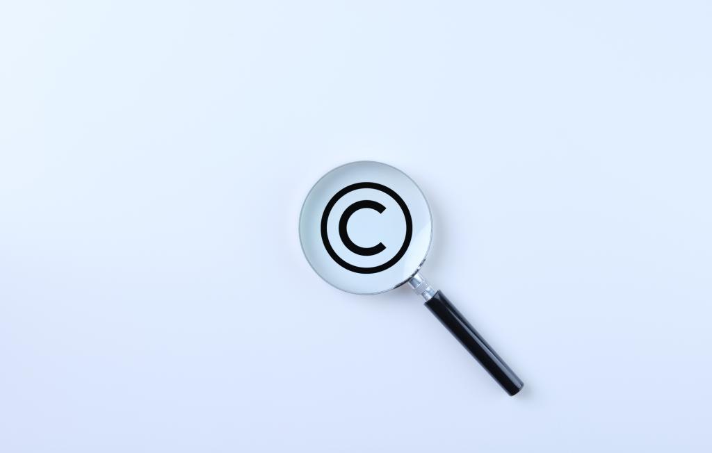 Magnifying glass magnifies the copyright symbol on a white background.