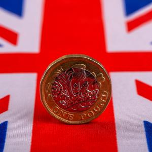 A one great british pound coin on top of the union jack flag to symbolise the 2024 UK Autumn Budget