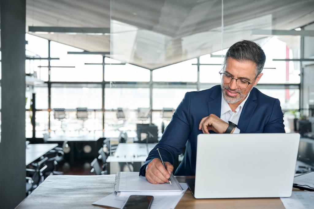 Middle aged smiling professional business man conducting a report on a business