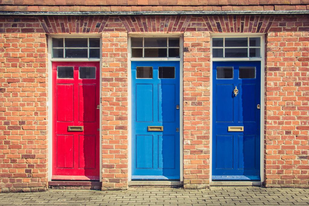 Three differently coloured front doors: red, light blue and dark blue.