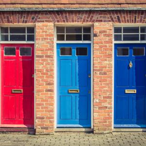 Three differently coloured front doors: red, light blue and dark blue.