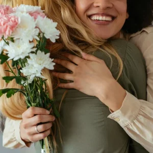 Two women hugging tightly and smiling