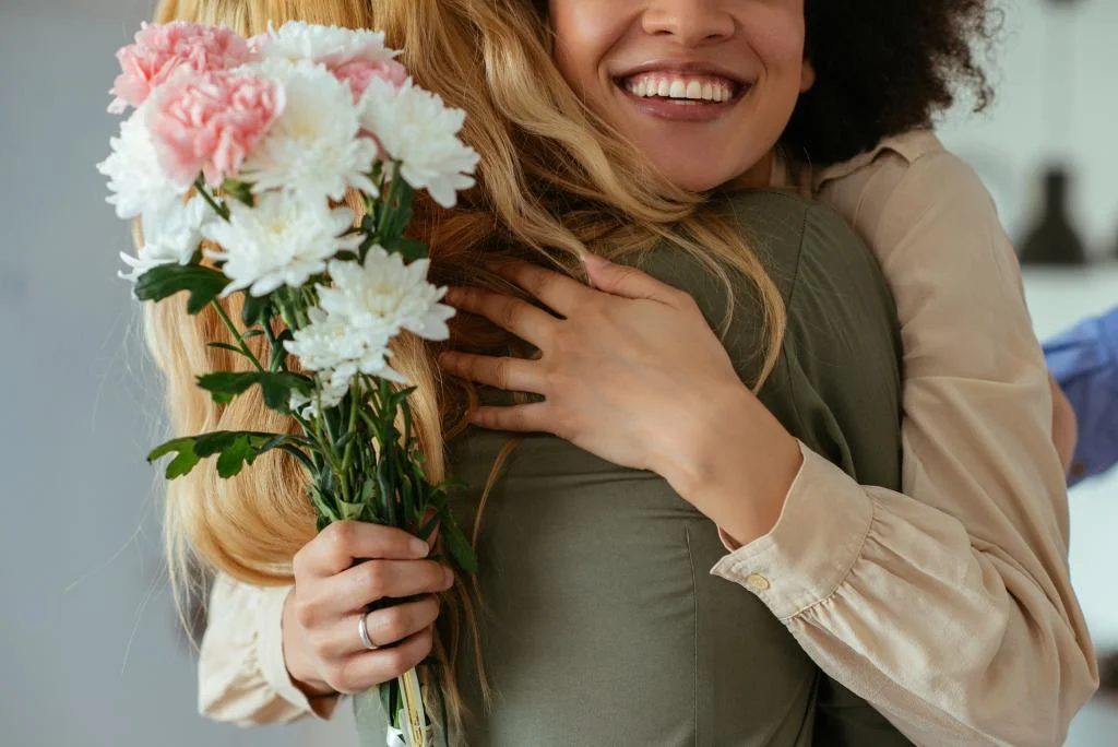 Two women hugging tightly and smiling