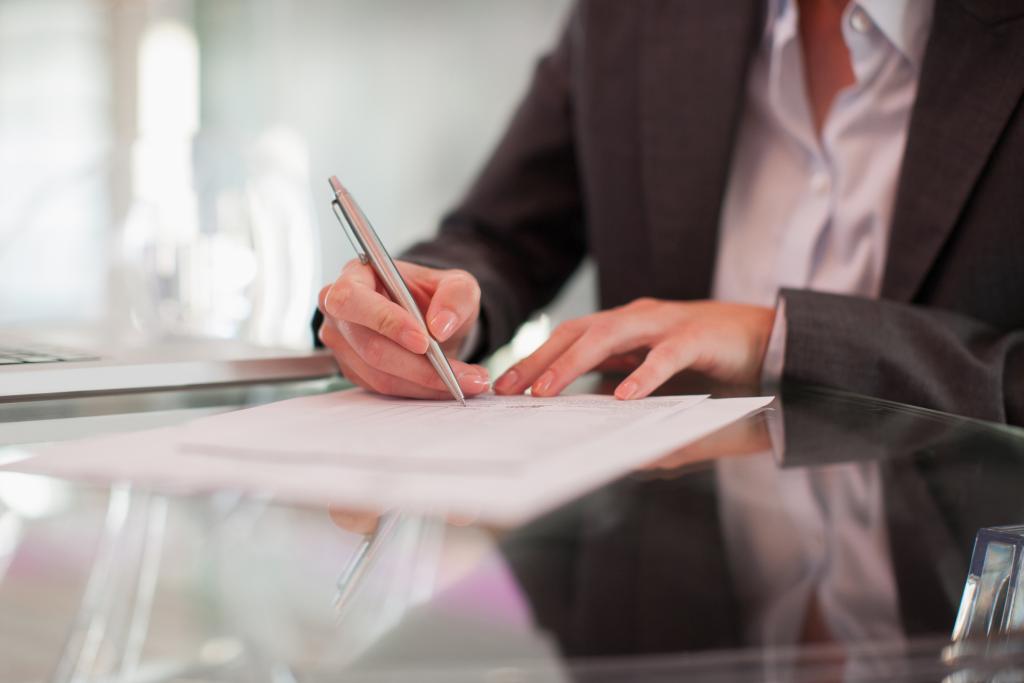 Businesswoman writing on paper at desk