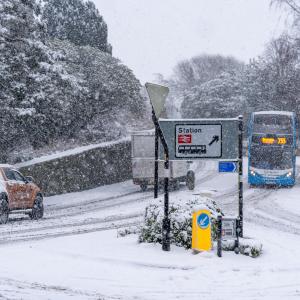 Vehicles driving on roads with heavy snow