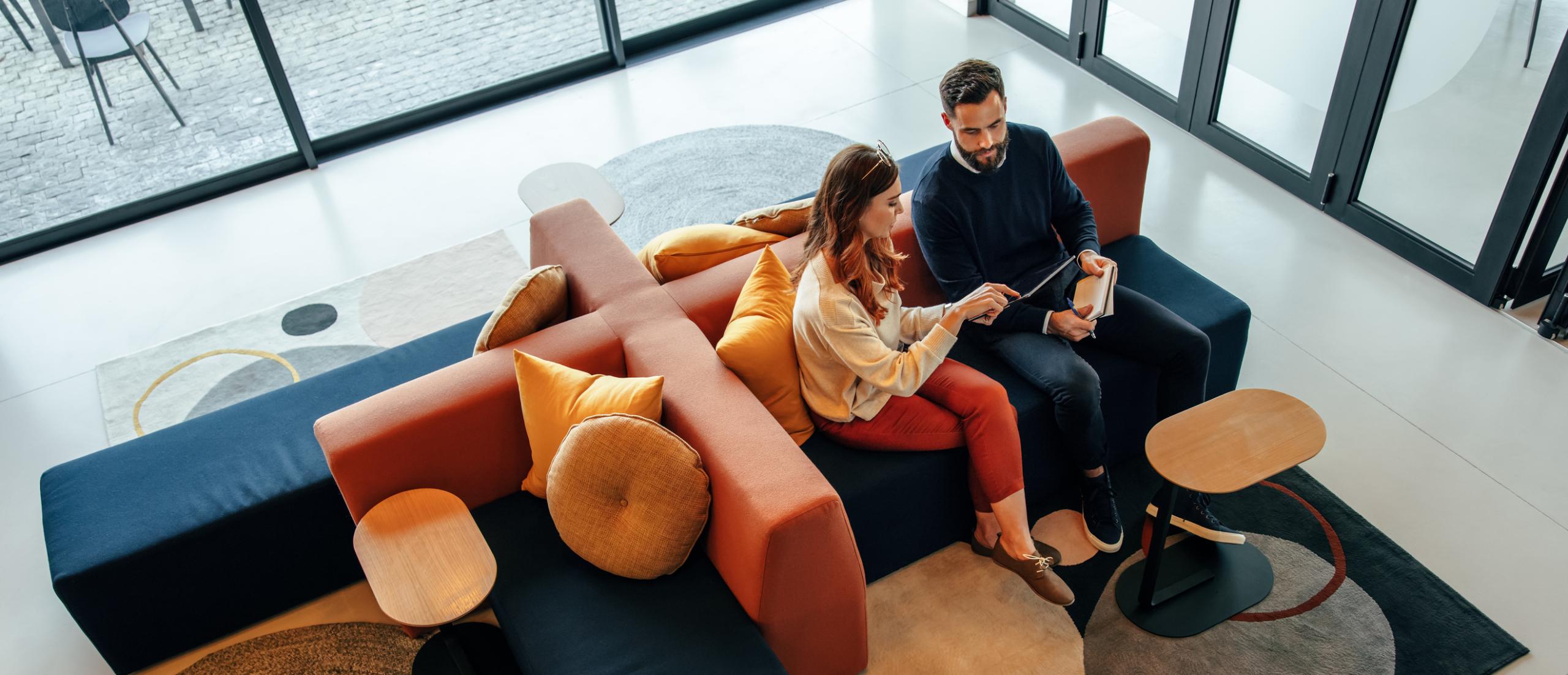 High angle view of two businesspeople working in an office lobby.