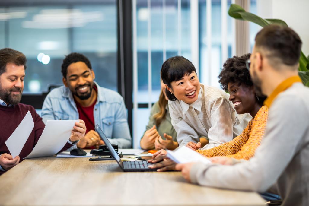 Colleagues of various ethnicities working together and laughing.