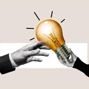 Concept for protecting a brand or creative idea - showing hands reaching out to touch a lightbulb