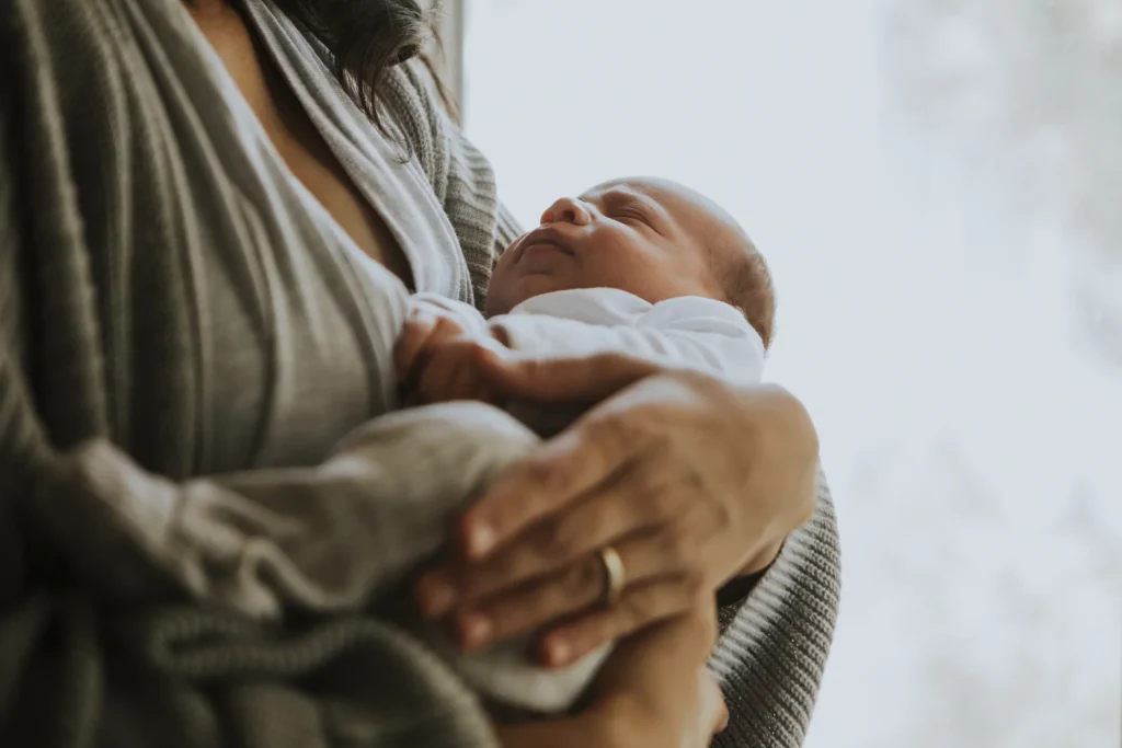 A mother holding a young baby close to her chest